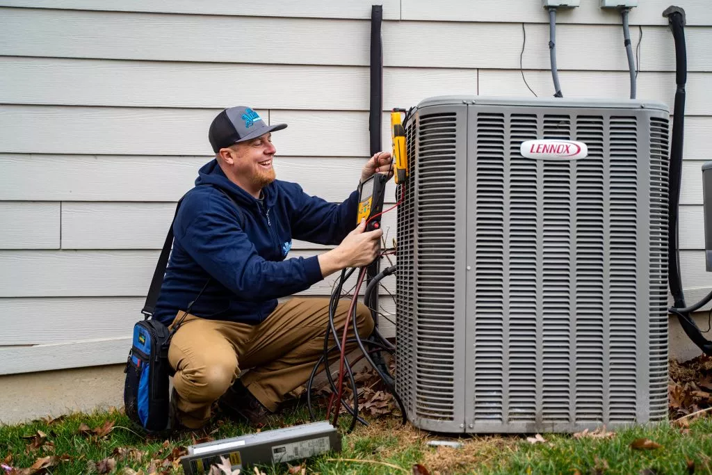 Technician performing maintenance on a Lennox air conditioning unit, showcasing expert HVAC service in Des Peres, MO.