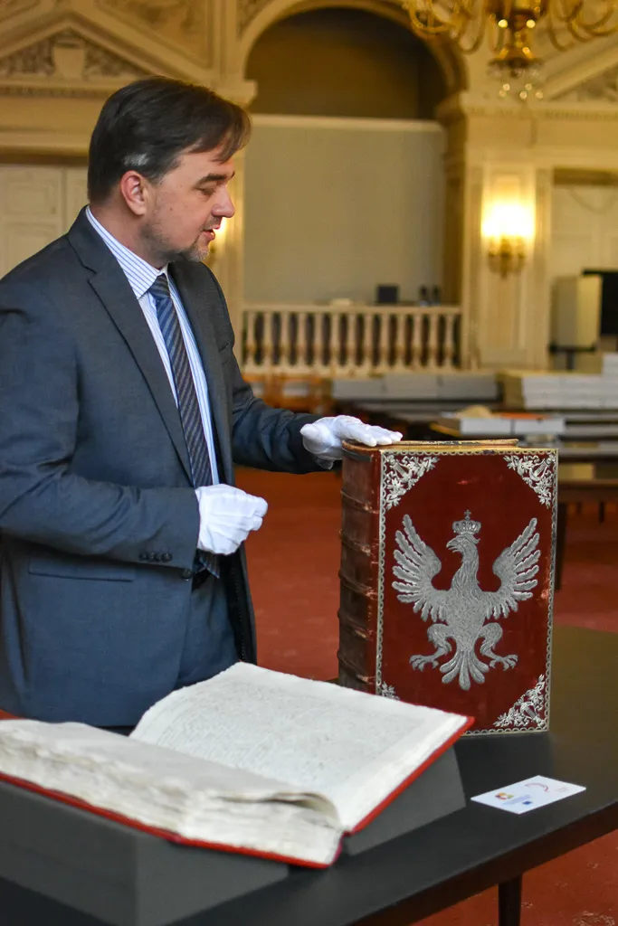 Dyrektor z egzemplarzem Konstytucji 3 Maja i ozdobnym czerwonym pudłem, w którym była przechowywana.