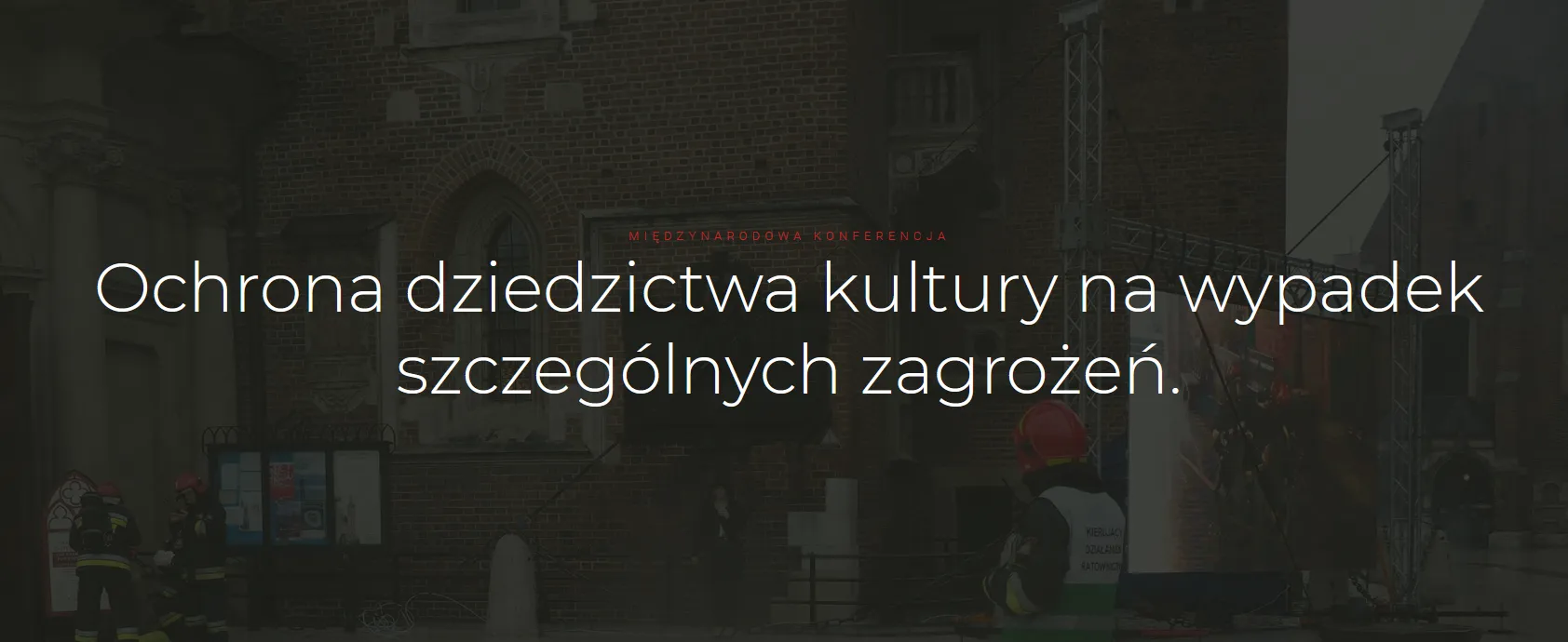Baner z tekstem „Ochrona dziedzictwa kultury na wypadek szczególnych zagrożeń”. W tle zdjęcie strażaków przed budynkiem.