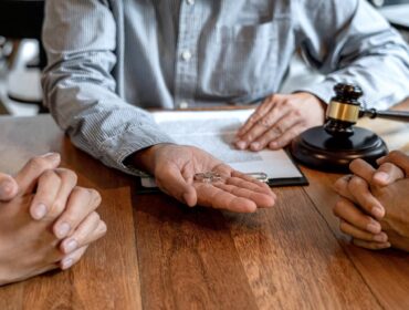Deux personnes aimables assises à une table avec un juge leur donnant un marteau pendant leur procédure de divorce.