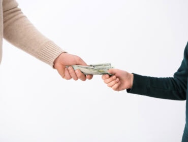 Man giving money to his son on light background. Concept of child support