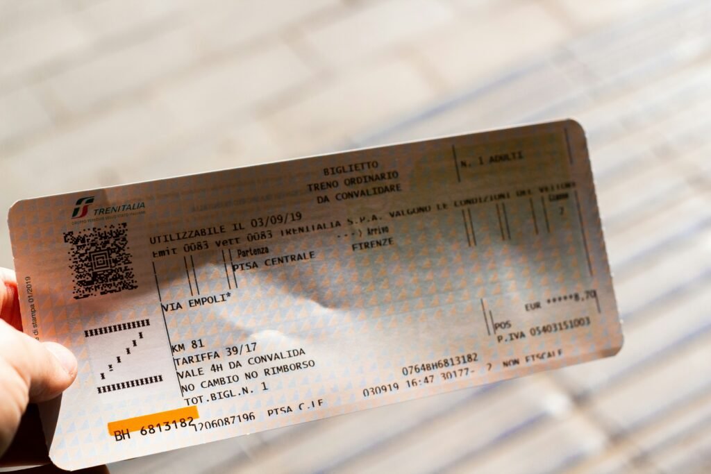 A person holding up a ticket for a concert A person holding up a ticket for a concert
