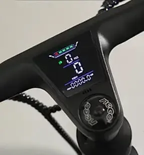 Primer plano de la pantalla digital Kosmos Nova7 en el manillar de un patinete eléctrico negro, que muestra indicadores de velocidad y batería sin problemas.