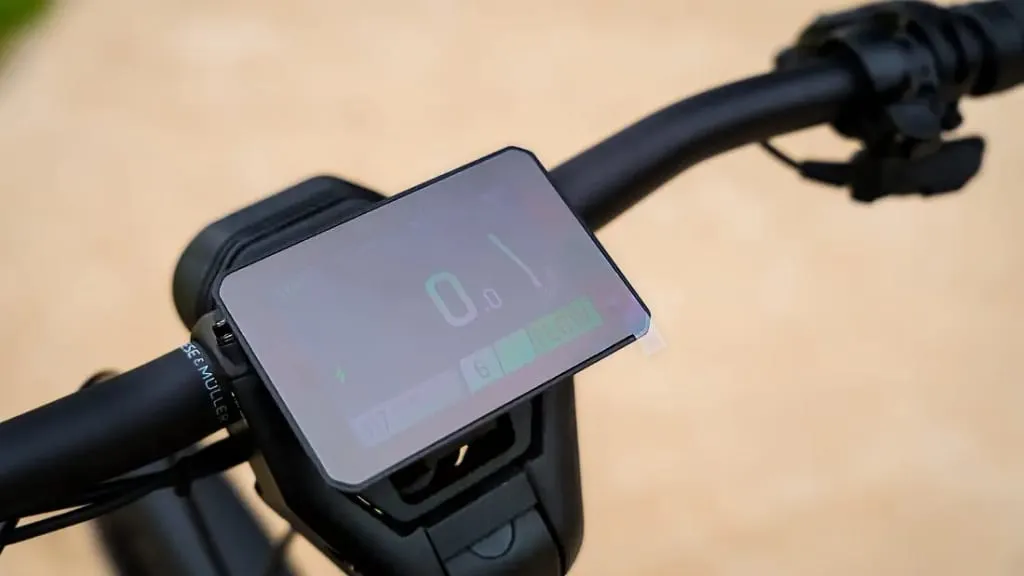 Primer plano del manillar de una bicicleta eléctrica que incluye una pantalla digital con tecnología de vanguardia de inspiración urbana que muestra la velocidad y otra información del recorrido.