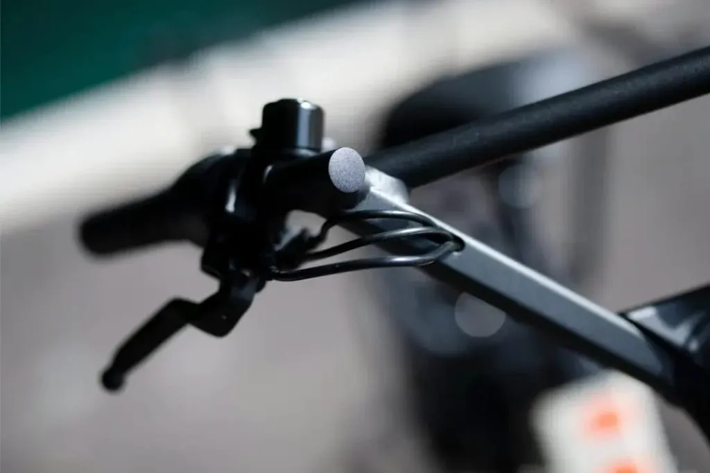 Primer plano de un manillar de bicicleta Moustache Lundi 20 Cargo con una palanca de freno y cables conectados.