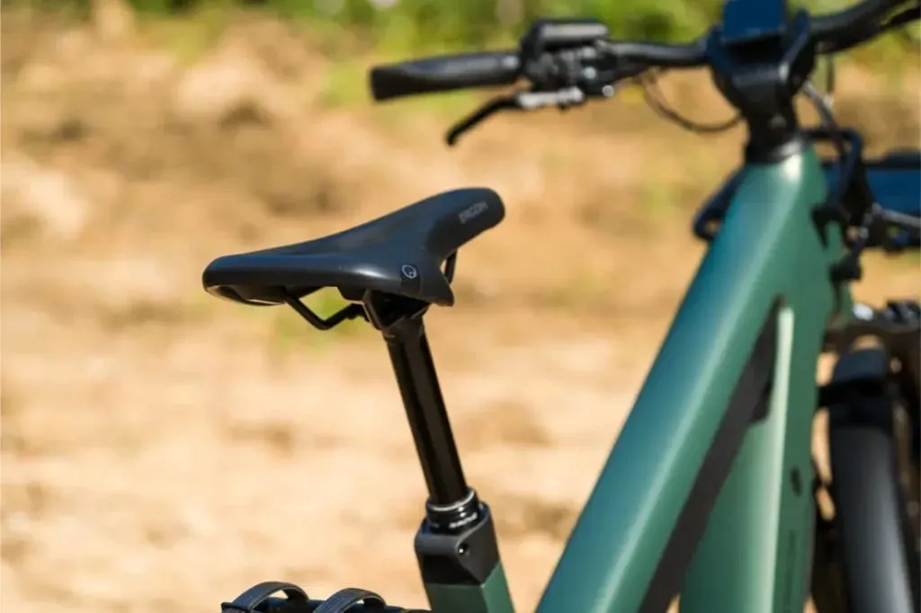 Primer plano de un sillín y un cuadro de bicicleta Riese & Müller Superdelite5 GT con manillar, al aire libre en un día soleado.