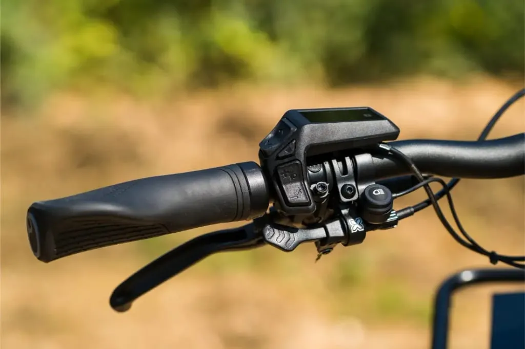 Primer plano de un manillar de bicicleta Riese & Müller Superdelite5 GT rohloff con pantalla digital y varios botones de control, listo para tu próxima aventura al aire libre.