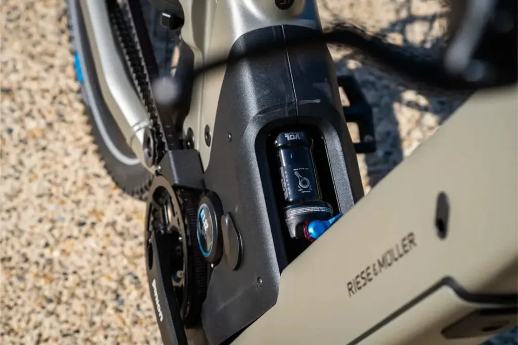 Primer plano de un cuadro de bicicleta eléctrica Riese & Müller Homage5 con diseño de paso bajo, en el que destaca el logotipo y el componente de suspensión incorporado.
