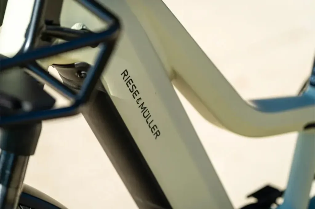 Primer plano de un cuadro de bicicleta con el nombre de la marca "Riese & Müller" impreso en él, con el robusto diseño del Multicharger3 Mixte Vario de Riese & Müller.