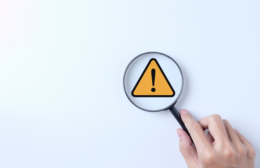 image_Warning,Alert,System,Concept.,Magnifying,Glass,Focused,On,Yellow,Triangle