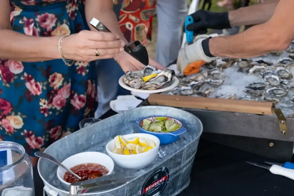 Freshly shucked oysters with lemon, lime, and sauce served from an ice display.