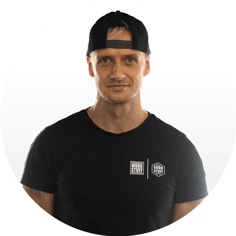 Piotr Nowogórski A man wearing a black t-shirt with “Work Stuff” and “Good Stuff” logos and a backward black cap, standing against a plain white background.