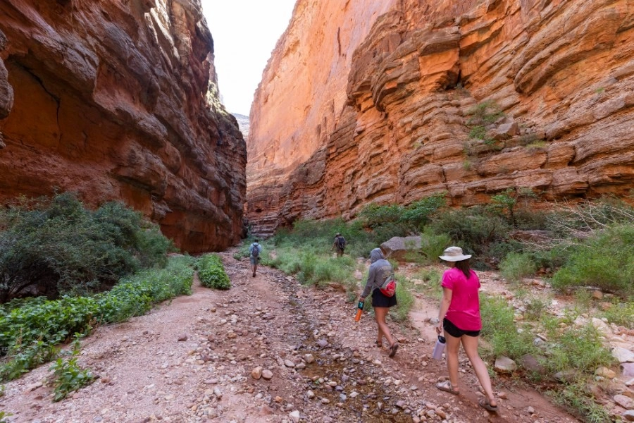 Side Hikes on a Grand Canyon River Trip: What You Need to Know 2 people hiking in side canyon in Grand Canyon