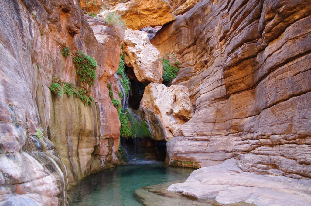 Waterfalls on a Grand Canyon Rafting Trip 4 Beautiful red rock grotto with pool beneath in Grand Canyon called Elves Chasm.