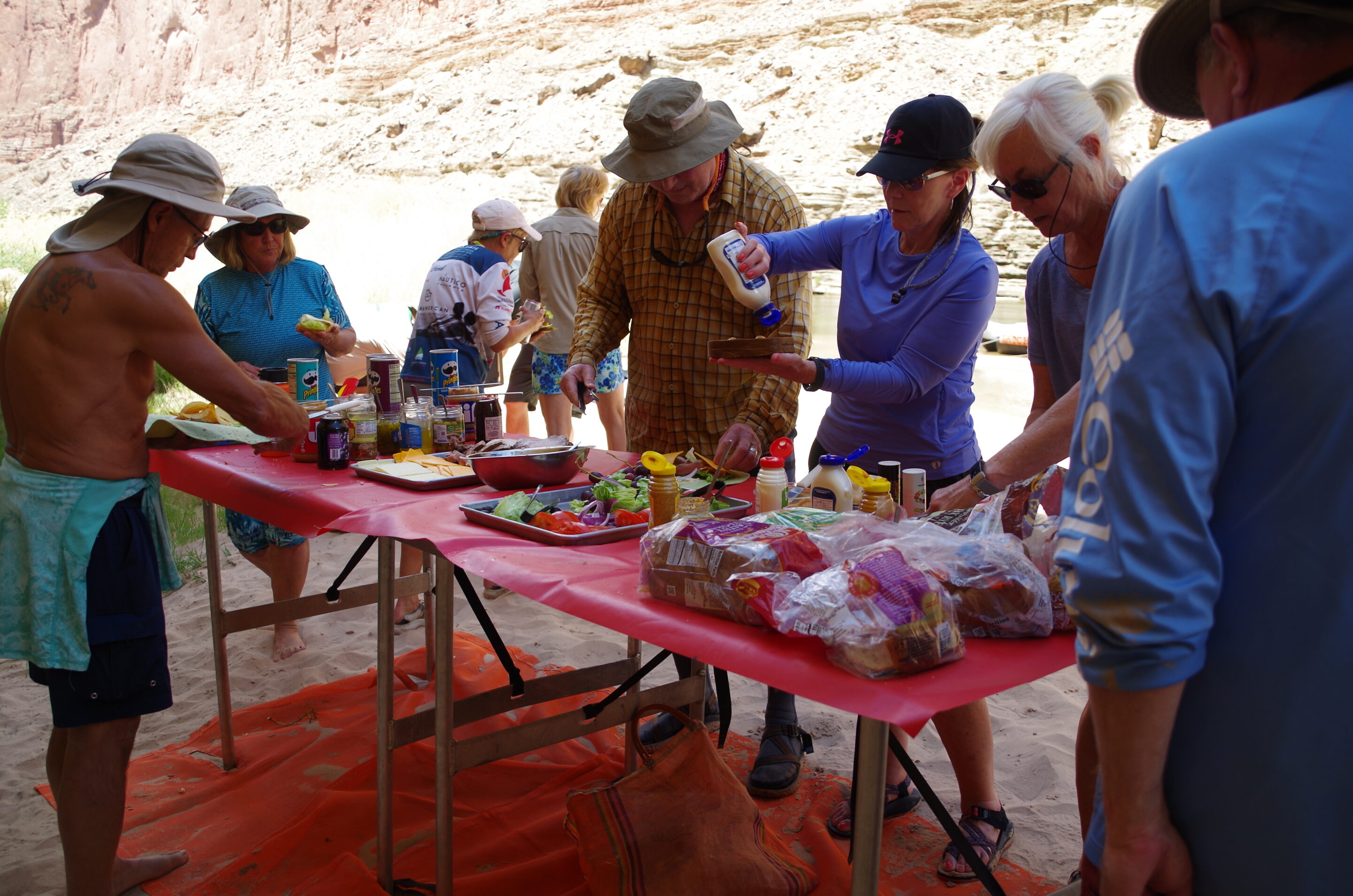 Eating on the River – Hatch Meals and How They Work 2 Hatch guests gathered around the lunch table making sandwiches. Photo credit: John Dillon.