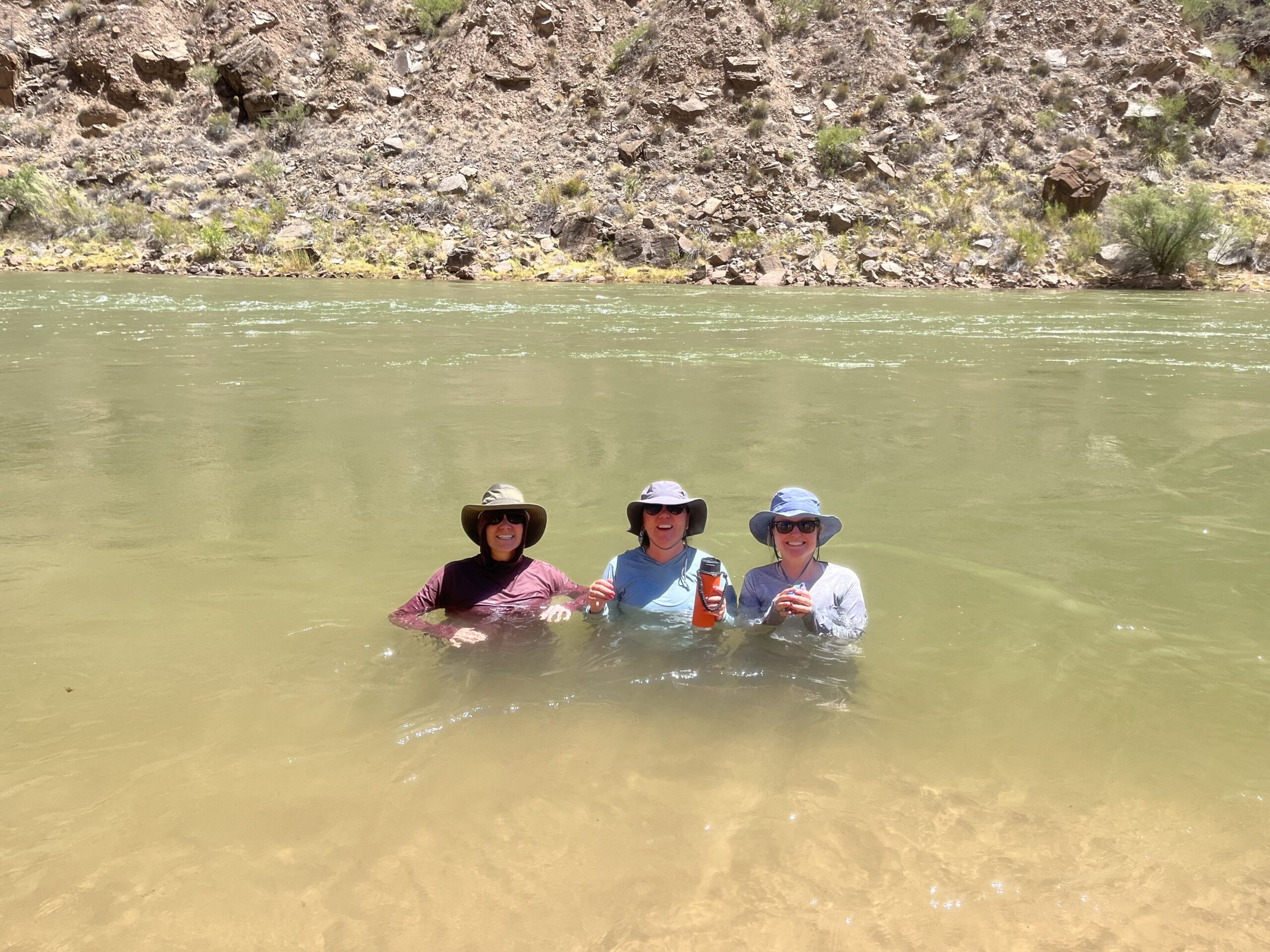 IMG_6612 Three Hatch guests stand chest deep in Colordo River wearing sun hats and sunglasses to protect themselves from the sunny Grand Canyon weather. Photo credit: Andy Hawk.