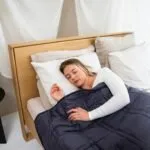 Do Weighted Blankets Actually Help with Anxiety? Person sleeping peacefully under a heavy blanket
