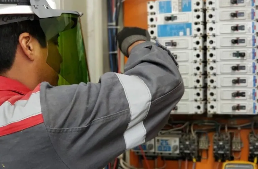 Digital Clamp Meter vs Digital Multimeter - Electrician testing voltage in an industrial breaker panel with a multimeter