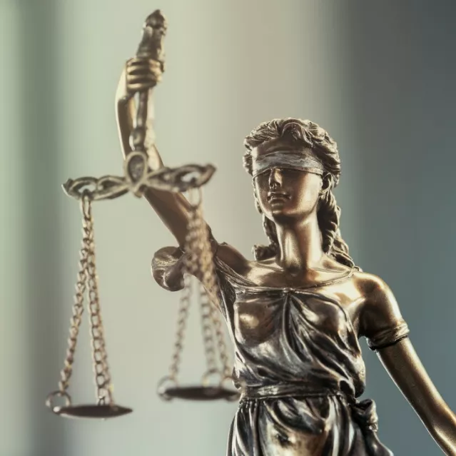 hathaway_and_kunz_practice_areas_hero_image A bronze figure, Lady Justice, holding the scales of justice