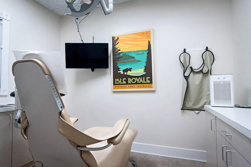 Dental operatory room with mounted television and framed poster, equipped for patient care at Knight Dental Care in Midland, MI