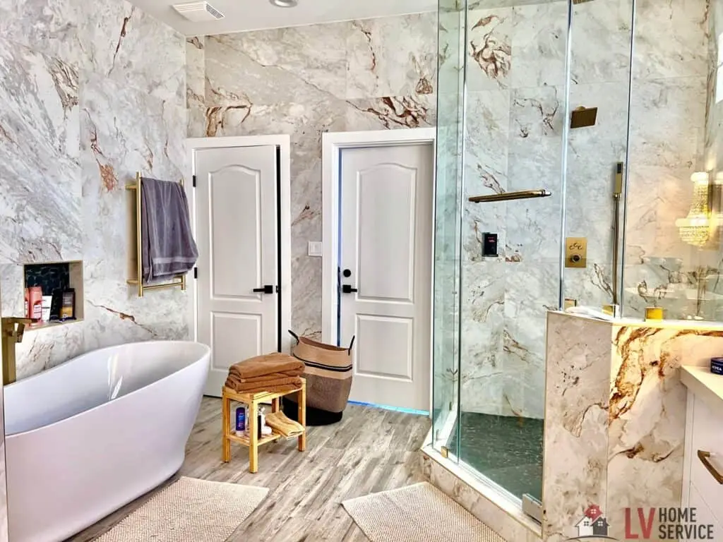 Luxurious bathroom with a freestanding tub, marble walls, glass shower, and wooden accents.