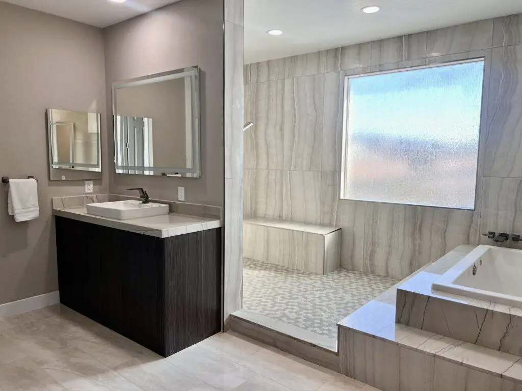 Spacious modern bathroom with dual sinks, large mirrors, a walk-in shower, and a bathtub.