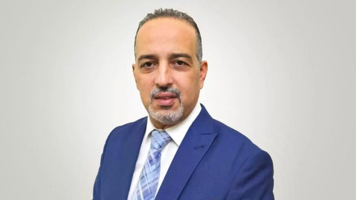 é’ã„スーツをç€ã¦æ¨¡æ§˜å…¥ã‚Šã®ãƒã‚¯ã‚¿ã‚¤ã‚’ç· ã‚ãŸç”·æ€§ãŒã€ä¸é–“色ã®èƒŒæ™¯ã«ã‚«ãƒ¡ãƒ©ã«å‘ã‹ã£ã¦ã€ã¾ã‚‹ã§å›½éš›ã‚«ãƒ³ãƒˆãƒªãƒ¼ãƒœãƒ¼ãƒ‰ä¼šè°ã«ã„ã‚‹ã‹ã®ã‚ˆã†ã«è‡ªä¿¡ã‚’æŒã£ã¦ãƒ—レゼンテーションをã—ã¦ã„る。