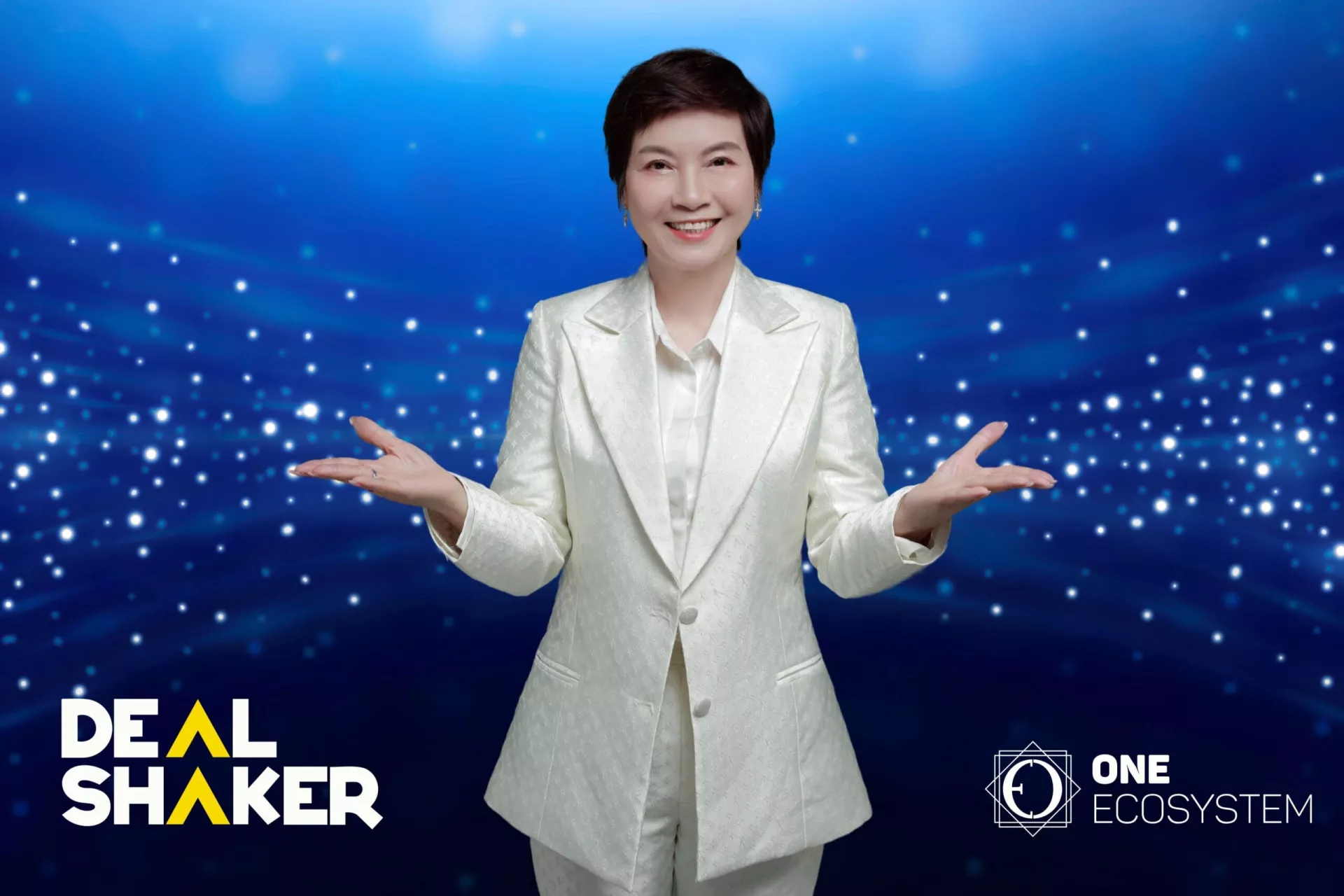 é’ã„背景ã«ç™½ã„スーツをç€ãŸäººç‰©ãŒä¸¡æ‰‹ã‚’広ã’ã¦å¾®ç¬‘ã¿ãªãŒã‚‰ç«‹ã£ã¦ãŠã‚Šã€ãƒ™ãƒˆãƒŠãƒ ã®é…力を体ç¾ã—ã¦ã„る。コーナーã«ã¯ã€ŒDeal Shakerã€ã¨ã€ŒOne Ecosystemã€ã®ãƒã‚´ãŒè¡¨ç¤ºã•れã€åŠ¹æžœçš„ãªè²©å£²ä¿ƒé€²æˆ¦ç•¥ã‚’強調ã—ã¦ã„ã¾ã™ã€‚