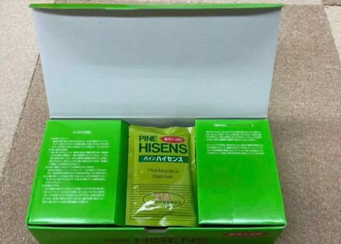 緑色の箱からは「パインハイセンス」とラベルが貼られた封印されたパッケージが現れ、別の言語で追加のテキストが記載されています。おそらく薬用入浴剤が入っていると思われるパッケージは同じ色合いを保っており、さわやかな深みの中に興味深い謎を示唆しています。.