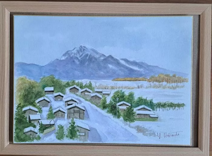 曇り空の下、山や木々を背景に、数軒の家がある雪に覆われた村を額装した風景水彩画。のどかな冬の風景は、甲斐駒ヶ岳や甲斐の林道の穏やかな美しさを思い起こさせるかもしれません。.