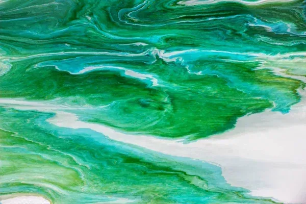 Abstract image with swirling patterns of green, teal, and white resembling marbled paint or flowing water. The fluid shapes blend smoothly, creating a vibrant and dynamic visual effect.