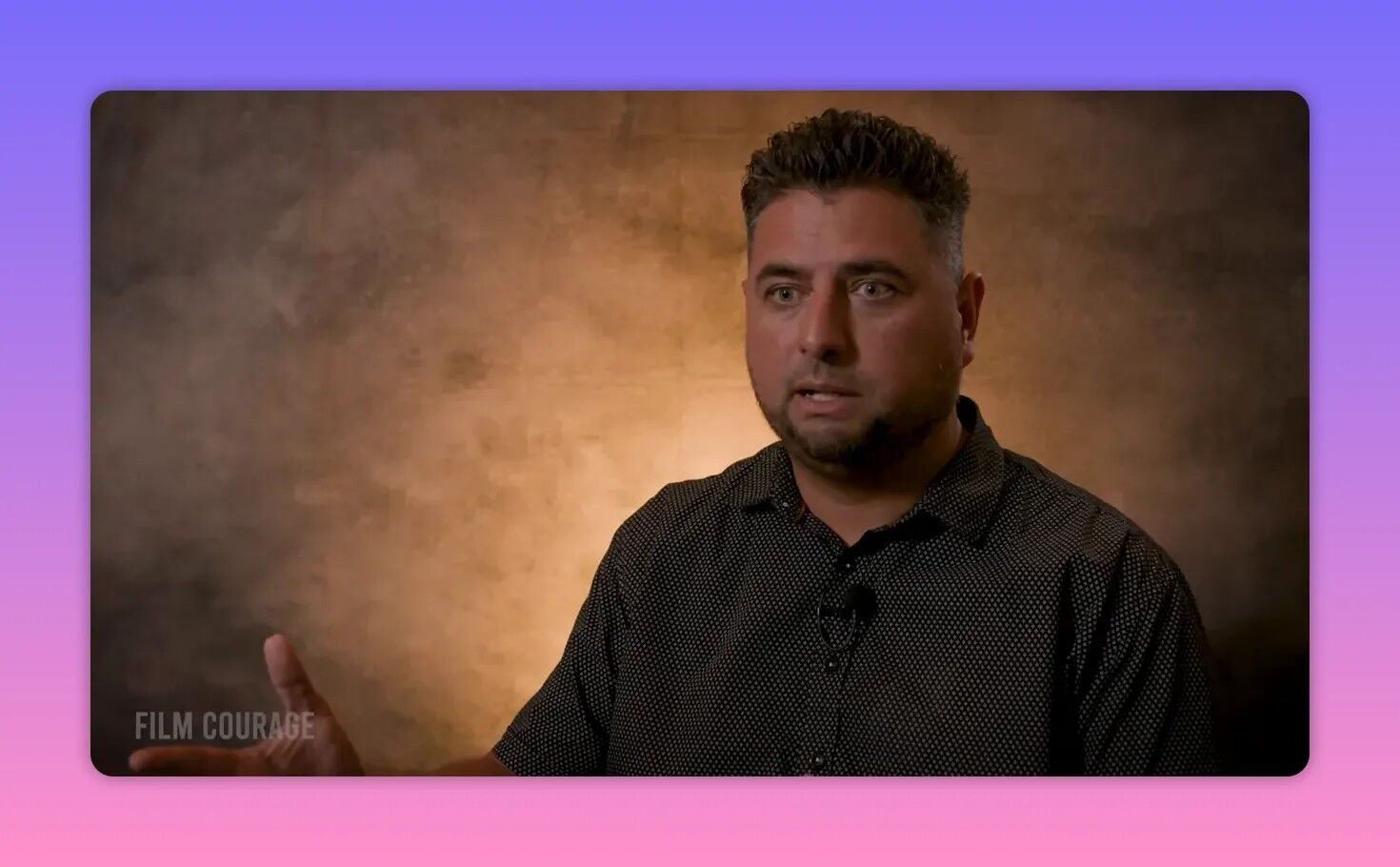 Filmmaker in a sharp interview frame against a warm backdrop, speaking earnestly and gesturing about festival strategy and acceptance.