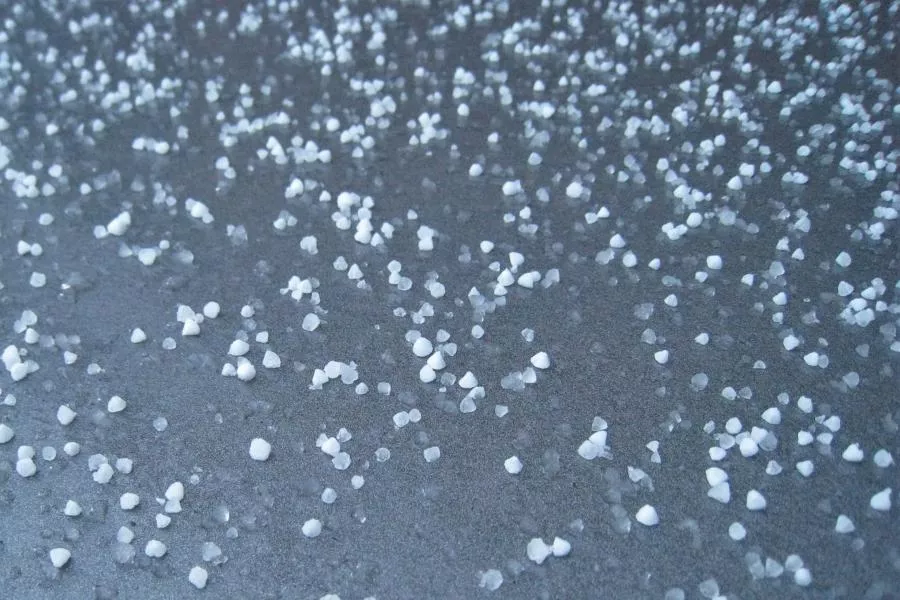 Hail stones on pavement documented by our Kyle TX roof repair team
