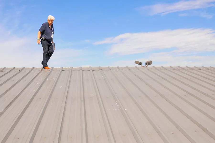 Man Inspection a Metal Roof