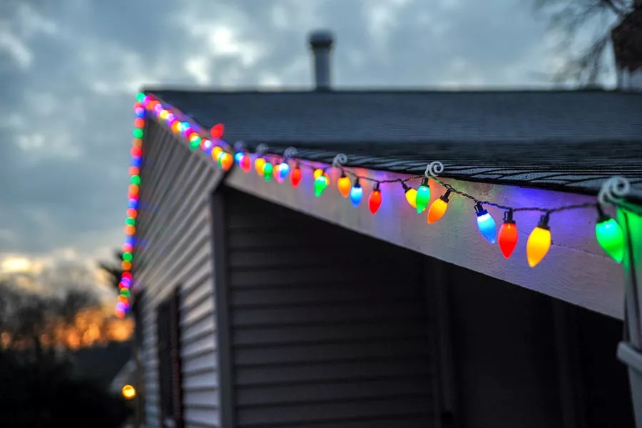 Christmas lights hung safely along a roof's edge with tips from our San Marcos roofing company contractors