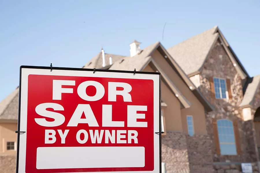 House with a new roof solar shingles in Seguin and a "For Sale By Owner" sign