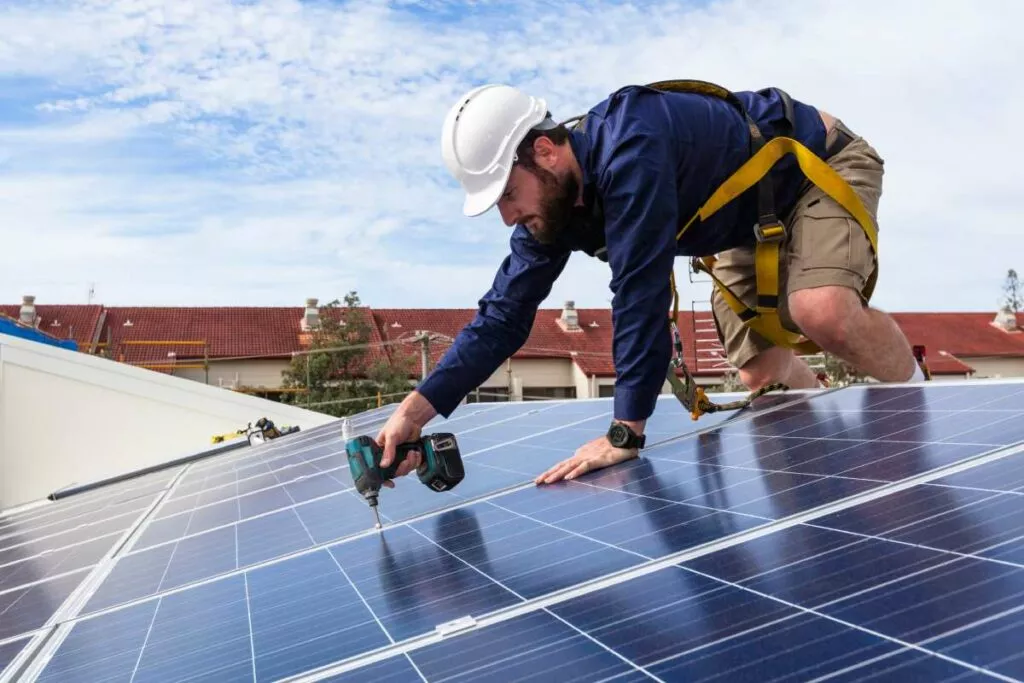 Technician installing solar panels on a home's roof