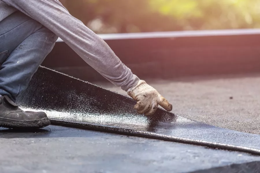 Roofing Contractor laying commercial coating on a roof