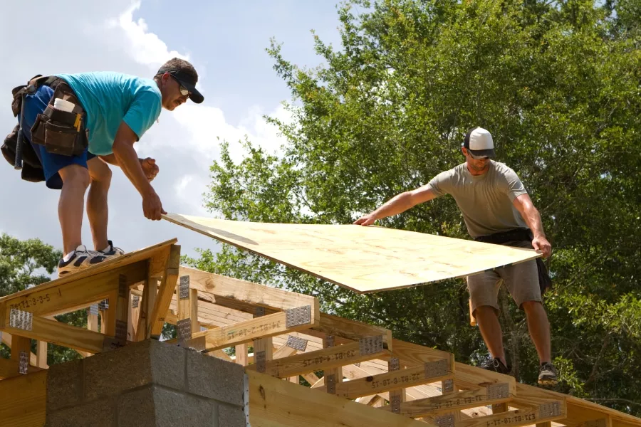 Two men installing roof sheathing for a roof repair in Wimberley TX