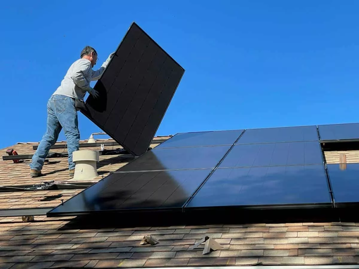 Kyle solar contractors performing maintenance on panels on a roof.