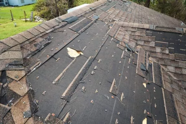 Damaged roof needing a free roof inspection in San Marcos, showing worn and missing shingles.