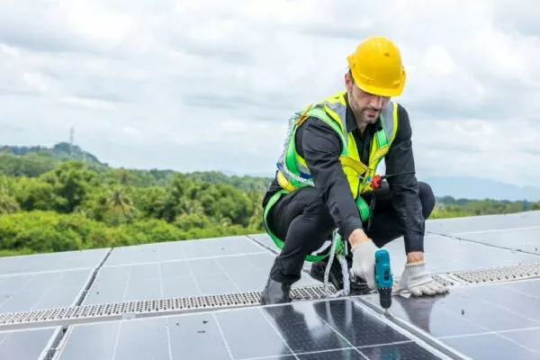 A worker installing solar panels during a project for commercial roofing in Austin.