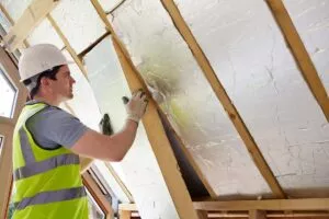 Worker insulating an attic as part of a Lockhart roof installation.