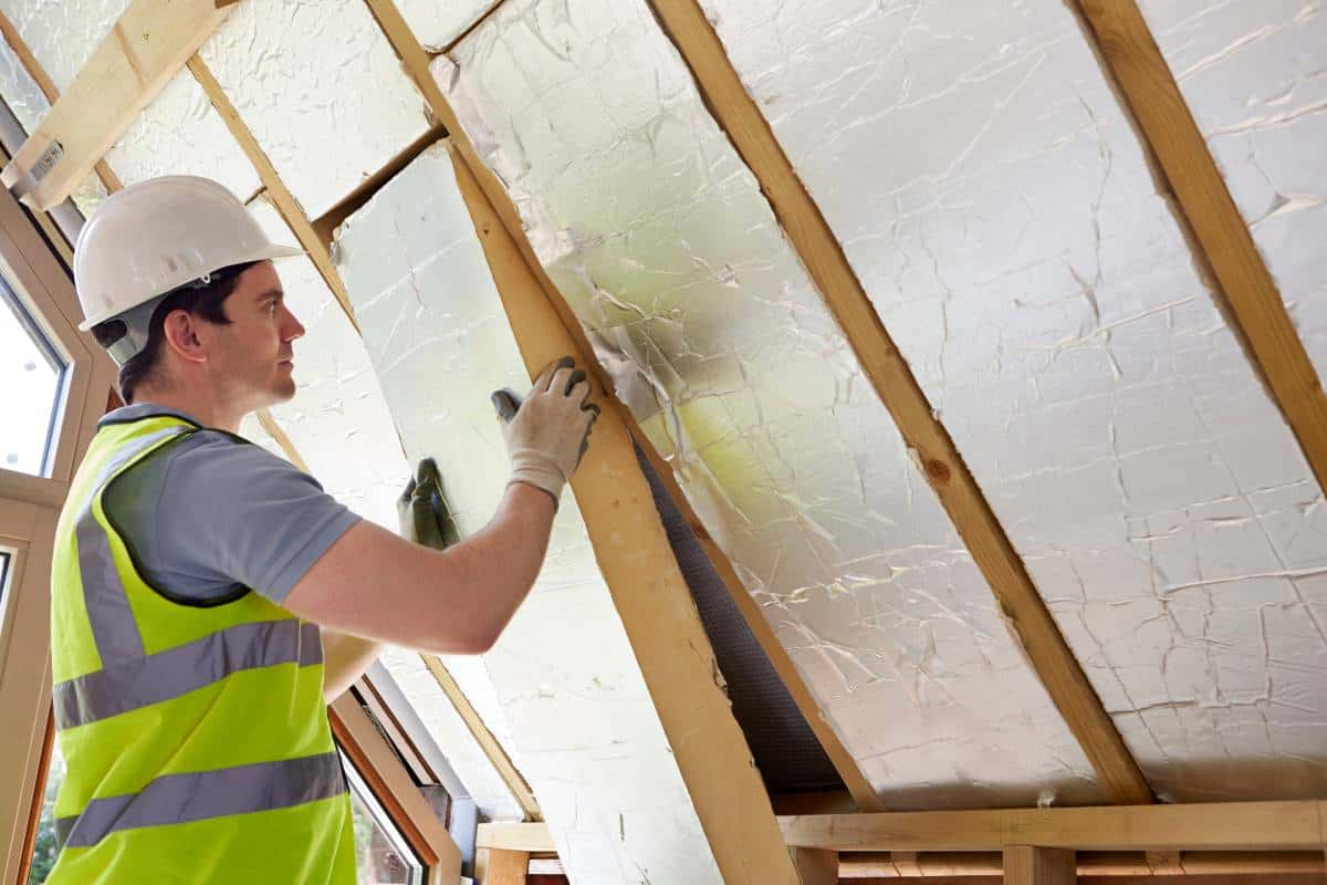 Worker insulating an attic as part of a Lockhart roof installation.
