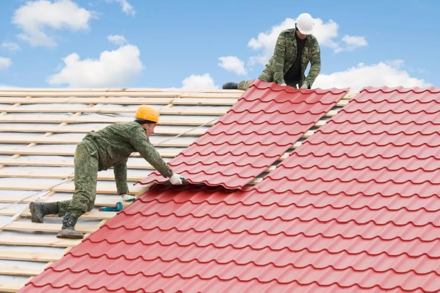 Workers installing New Braunfels metal roofs on a sunny day.