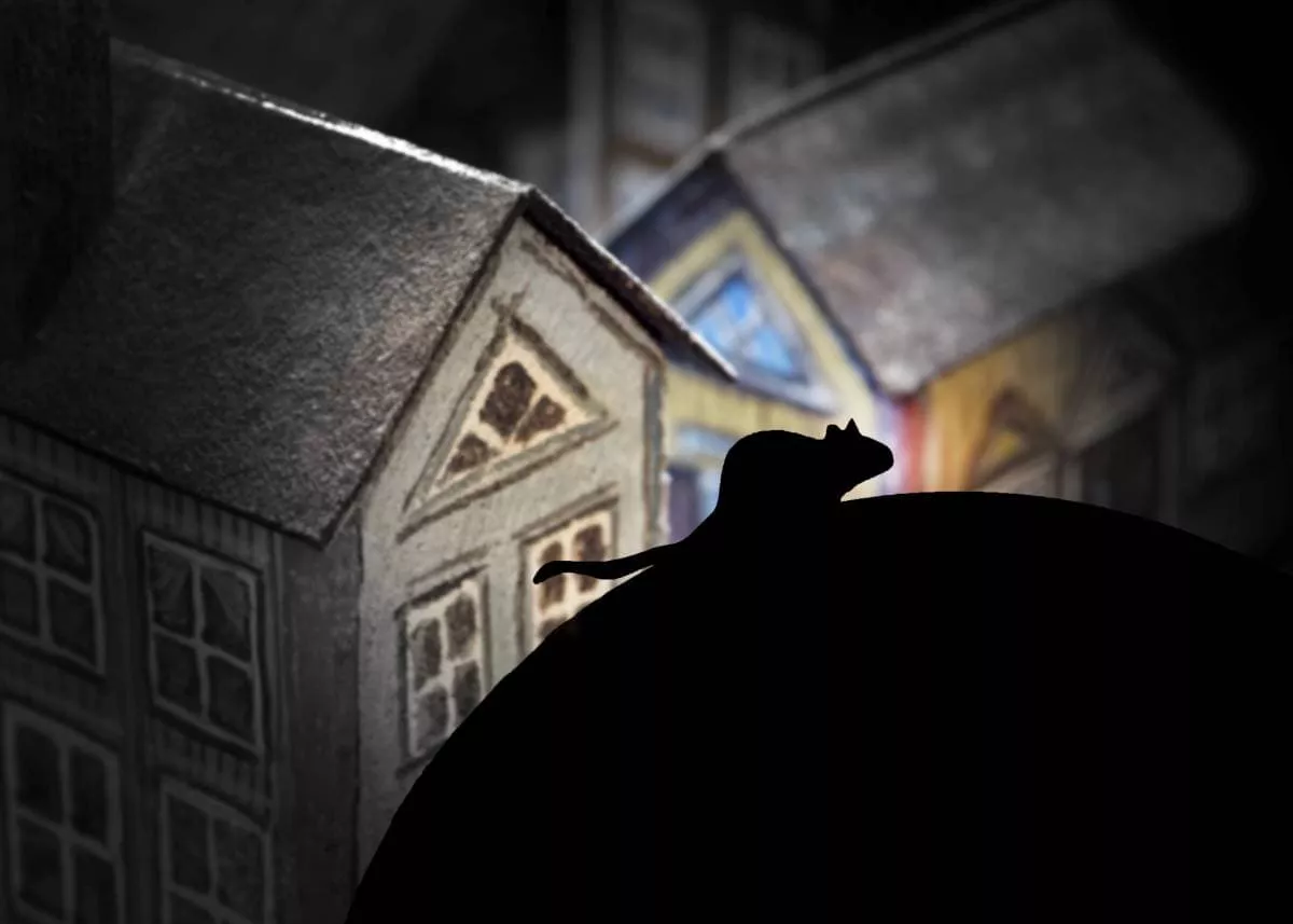 rat Silhouette Over Some Houses Roofs