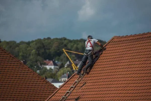 San Marcos roofers expertly working on a steep red tiled roof.