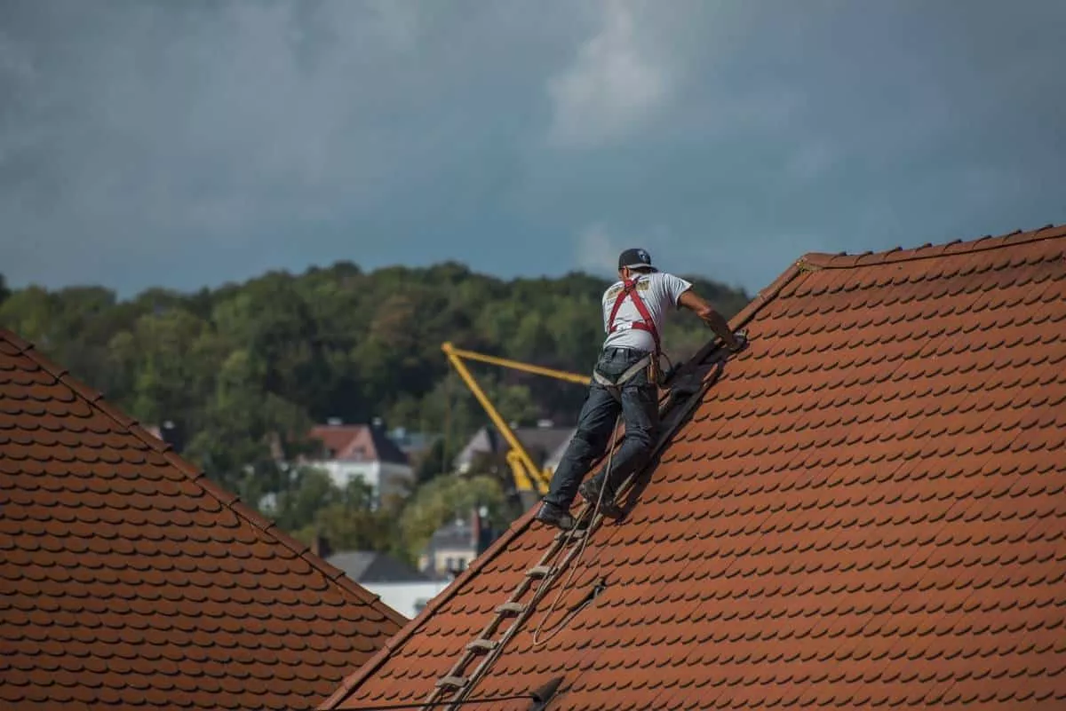 San Marcos roofers expertly working on a steep red tiled roof.