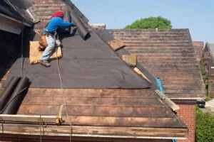 Seguin roofers putting down tar paper on old house during roof replacement
