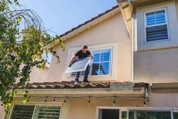 Man Doing Roof Repair and Upgrading to Solar Panel Roof